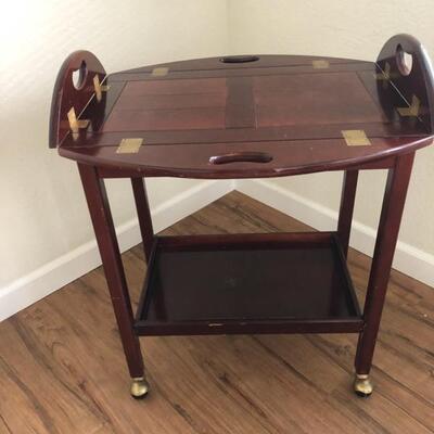 beautiful mahogany finish bar cart with removable tray. On wheels. Sides rise and lower.