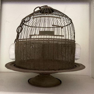 Old footed bird cage with ceramic feeder
