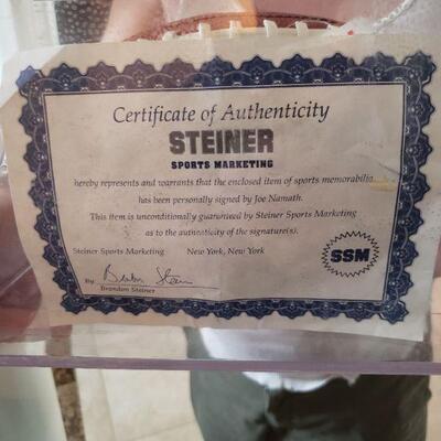 Certificate of Authenticity for the Joe Namath autographed football, under glass