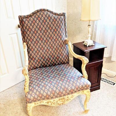 Upholstered armchair with carved legs