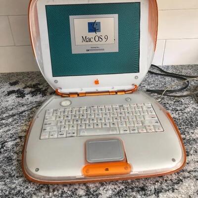 Vintage Apple Mac Clamshell laptop with accessories.