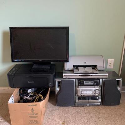 This is a collection of various electronic devices. An AOC computer monitor, Canon MG3222 printer, AIWA stereo/CD/Cassette player, Sanyo...