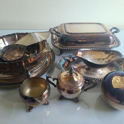 Twelve silver plated dishes. Some plates, some decorative. Largest plate measures 13