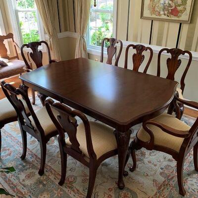 Kincaid cherry dining room table with 2 leaves and 8 matching chairs, 2 are captains chairs. There is also a protective cover as well....