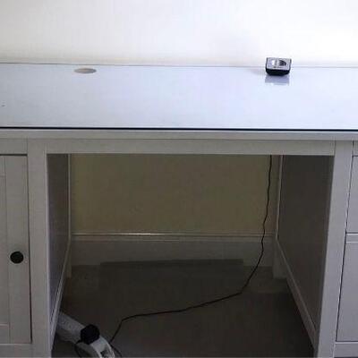 White desk with a cabinet door and two drawers. Desk has a glass top and measures 61x26x30