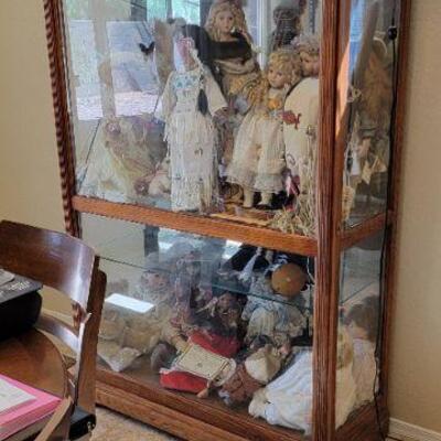 Glass display cabinet with collectible porcelain dolls