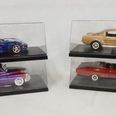 1261	LOT OF FOUR DIE CAST 1:18 SCALE MODEL CARS IN DISPLAY CASES.
