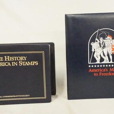 1034	LOT OF TWO COMMEMORATIVE STAMP ALBUMS; THE HISTORY OF AMERICA IN STAMPS & AMERICAS MARCH TO FREEDOM
