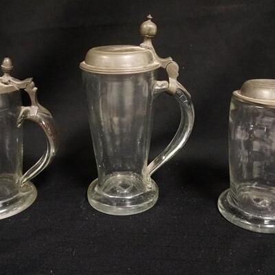 1168	3 ANTIQUE BLOWN GLASS STEINS W/ PEWTER LIDS. TWO HAVE ACORN FINIALS. APPLIED HANDLES. ONE HAS A BASE CHIP
