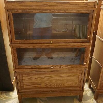 1180	OAK 3 SECTION BARRISTER BOOKCASE HAS ONE BLIND DOOR. 34 IN W, 11 IN DEEP, 51 IN H 
