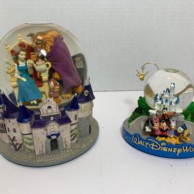 These are Disney themed Snow Globes. One is music and plays Beauty and The Beast and the other one is Magic Kingdom with Mickey and...