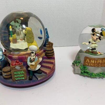 This is a Lady and the Tramp musical snow globe and the village lights up behind it with 2 included AA batteries. The other is themed...