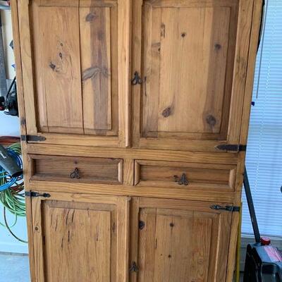 Tall wooden cabinet made of pine that can fit multiple things. Tools are not included. Measurements: 79 in x 46 1/2 in x 50 in 