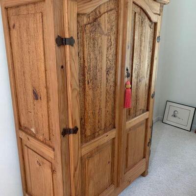 Rustic pine armoire with distressed look handles and hinges. Armoire has three levels of space to put a tv or to store clothes or other...