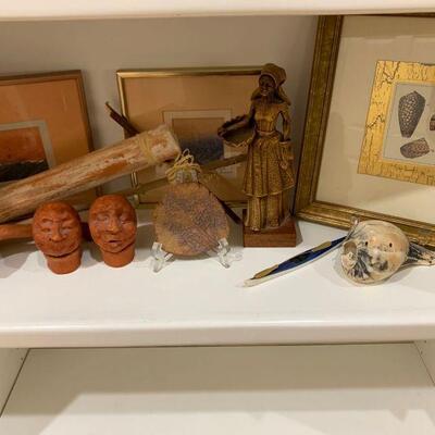 This lot includes two signed watercolors, three clay rattles that are an orange/red, red faded tree branch, a unique sea shell, brown...