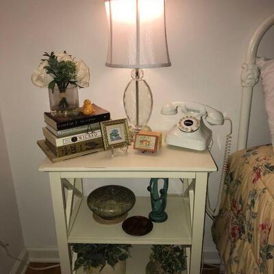 This lot contains some bedroom decor pieces including some pottery pieces, faux plants, books, 2 lamps and an old phone....