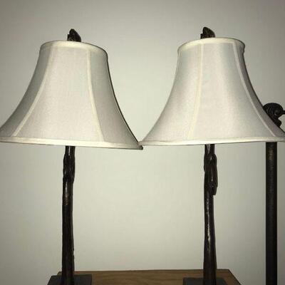 Matching pair of brushed bronze color wrought-iron lamps with a flourish at the top. Both are in working condition....