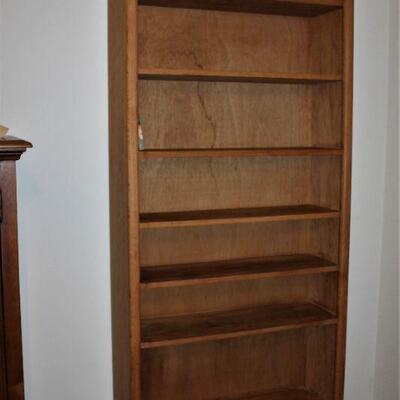 Wooden bookcase has plenty of storage and we have plenty of books to fill it up.