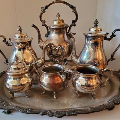 Silver on copper tea and coffee set. Includes tray, sugar bowls, creamer, tea pot, coffee pot and a teapot on tilting stand with burner....