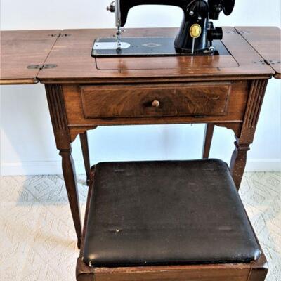 Vintage (early 40's) Singer Sewing machine and cabinet. Has matching bench with storage under bence seat. 