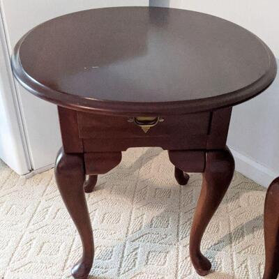 One of a pair of mahogany oval end tables with Queen Anne legs and center drawer