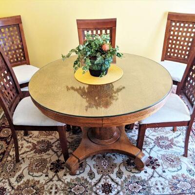 Antique, nice round oak table with scrolled legs.  Has custom made glass protector for top