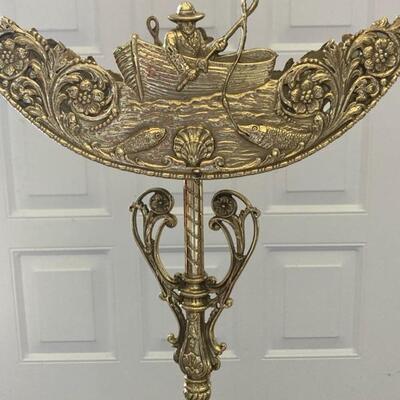 This brass plant stand measures 33" tall and has a 'boating' motif.  Notice green glass detail.  Priced at $195.