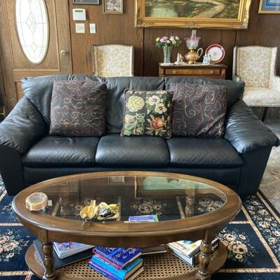 One of two black leather sofas.  This sofa is priced at $125 because it has a tear under the arm.  