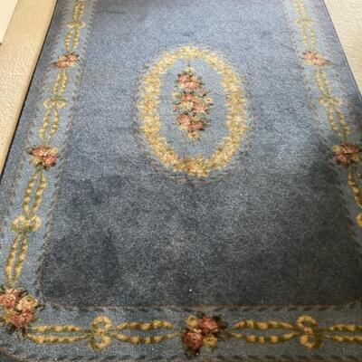This Wedgewood blue rug with floral centerpiece measures 5' x 7.5' Priced at $75