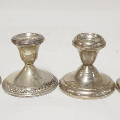 1197	TWO PAIRS OF WEIGHTED STERLING SILVER CANDLESTICKS, ONE IS TWISTED UNDER THE CUP
