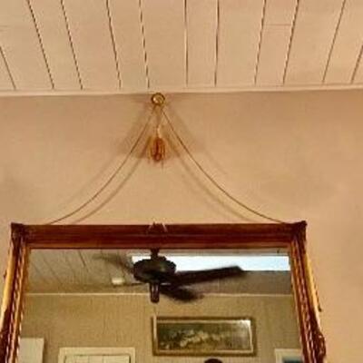 Pair of swag chandelier ceiling lights on either side of this large wall mirror