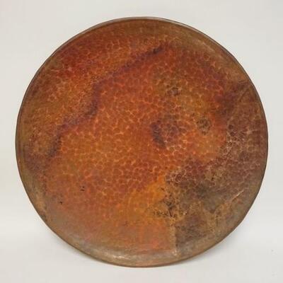 1107	HEAVY HAMMERED COPPER HANGING PLAQUE HAS ROLLED EDGE, 23 3/4 IN DIAMENTER. 
