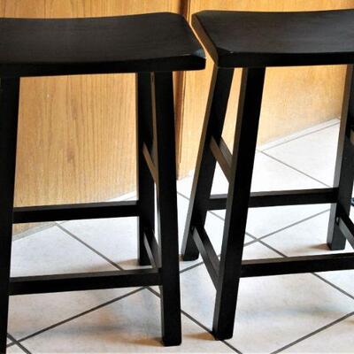 A pair of black wooden barstools.