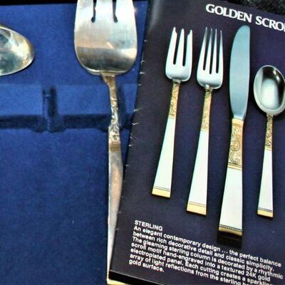 Sterling silver Gorham flatware with golden scroll design.