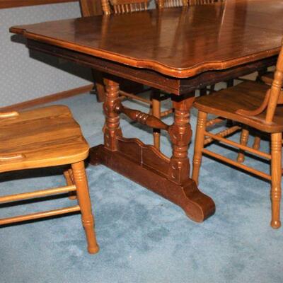 Large oak dining table with two leaves and eight ornately styled spindle chairs.