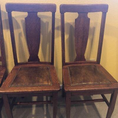 Closer view of matching pair of oak dining chairs.
