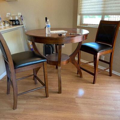 Small round dinner table and black leather chairs