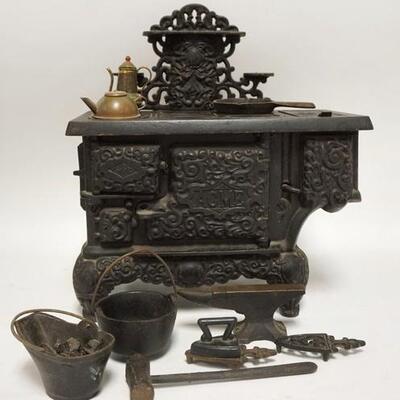 1266	ACME CAST IRON TOY STOVE W/ ACCSESSORIES 11 IN W, 12 1/2 IN H 
