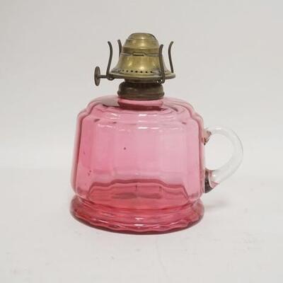 1094	CRANBERRY GLASS KEROSENE LAMP, APPLIED CLEAR HANDLES, INTERIOR RIBBING, 5 3/4 IN HIGH
