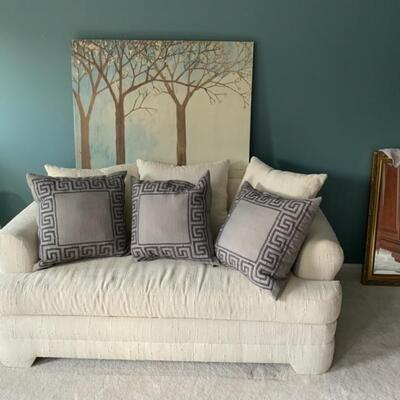 ivory loveseat, accent pillows, painting of trees on canvas