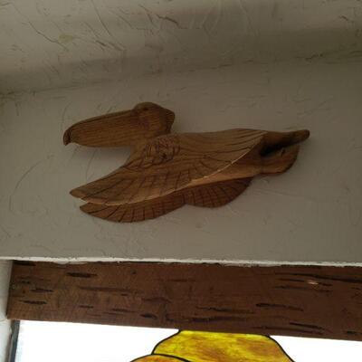 this is a wooden carving of a Pelican