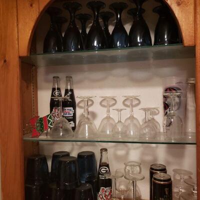 lots of memorabilia soda bottles and unique glassware