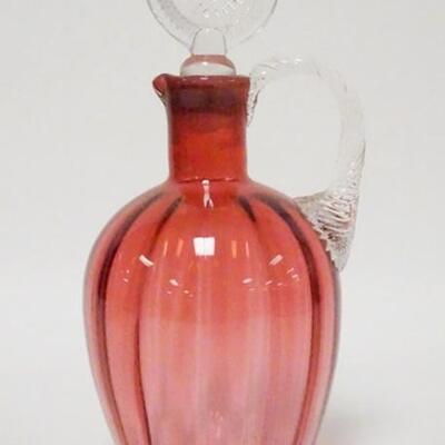 1057	BLOWN CRANBERRY JUG W/OPTIC RIB PATTERN, APPLIED TWIST HANDLE, WAFER STOPPER, POLISHED PONTIL, 9 3/4 IN HIGH
