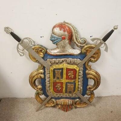 1309	CARVED WOODEN COAT OF ARMS, PAINTED, SWORDS ARE METAL, 34 IN HIGH X 35 IN WIDE
