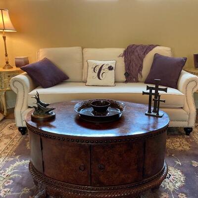White sofa, purple rug, oval coffee table