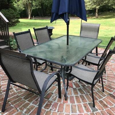 Outdoor dining table with sunbrella cushions, umbrella and stand