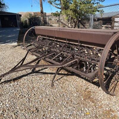 Lot 615 McCormick Deering Farm implement: Measures approximately 11â€˜6â€œ wide and the wheels are 48 inch in diameter.