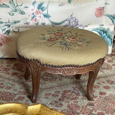 Padded footstool with needlepoint cover