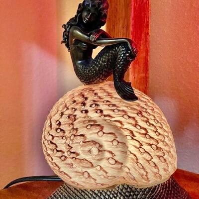 Mermaid sitting on lighted conch shell lamp