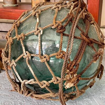 Blown glass fishing buoy with netting, found in Japan in the 1950s.